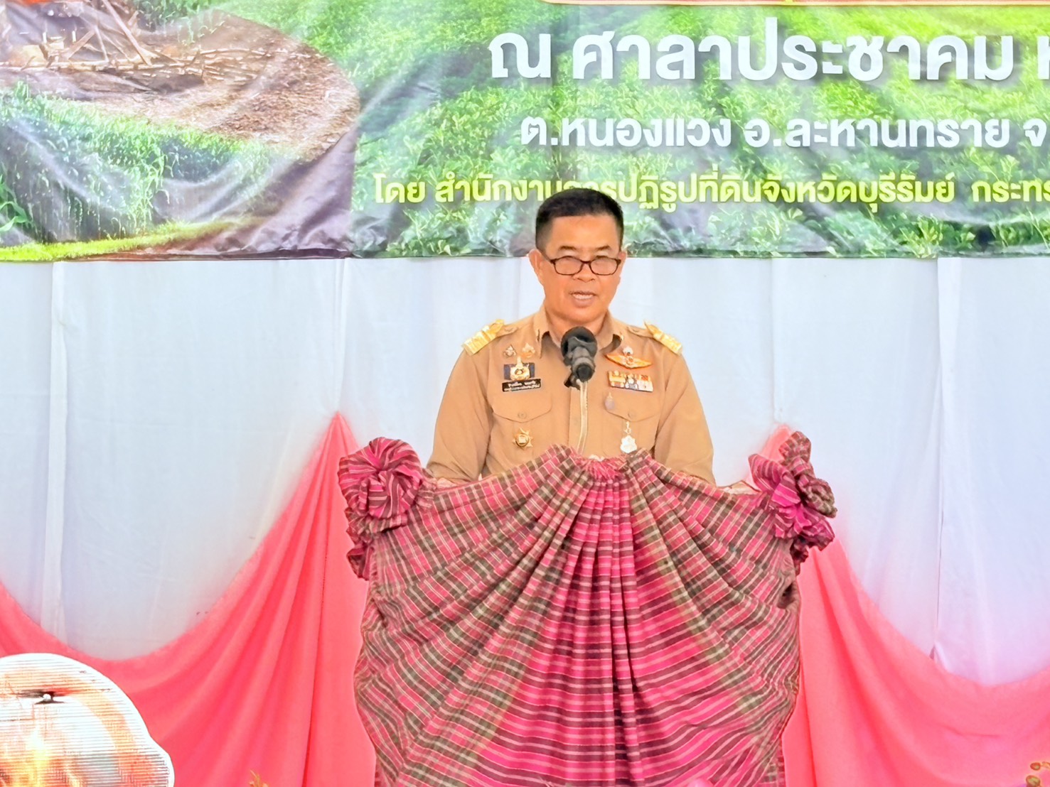 title - วันที่ 23 กุมภาพันธ์ 2569 นายประเสริฐ กาญจนเกียรติกุล ปฏิรูปที่ดินจังหวัดบุรีรัมย์ พร้อมเจ้าหน้าที่ ส.ป.ก.บุรีรัมย์ จัดโครงการอบรมก่อนมอบหนังสืออนุญาตให้เข้าทำประโยชน์ในเขตปฏิรูปที่ดิน (ส.ป.ก. 4-01) โดยมีนายคำเคลื่อน พณะชัย รองผู้ว่าราชการจังหวัดบุรีรัมย์ เป็นประธานในการมอบ ส.ป.ก. 4-01, โฉนดเพื่อการเกษตร แก่เกษตรกรที่เข้าร่วมโครงการ และร่วมรณรงค์ลดการเผาในเขตปฏิรูปที่ดิน